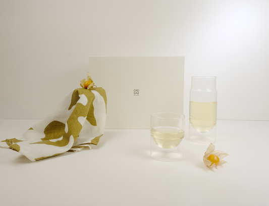 Carafe and Tumbler glass, with a printed teatowel on a light background