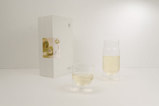 Carafe and glass with a wine box on a light gray background