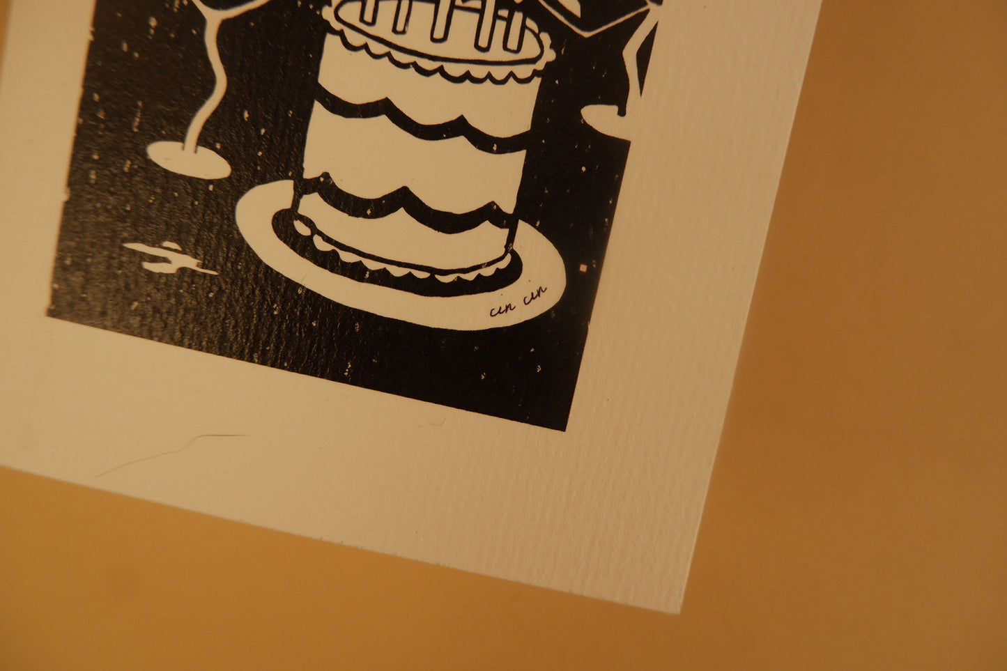 Black and white illustration of a cake on a beige background