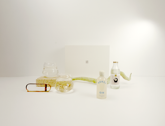 Bottle of Honey Gin with two glasses on a white surface