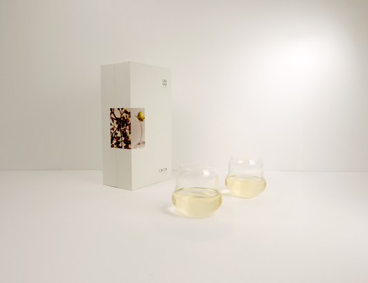 Two glass containers with a small box on a white background