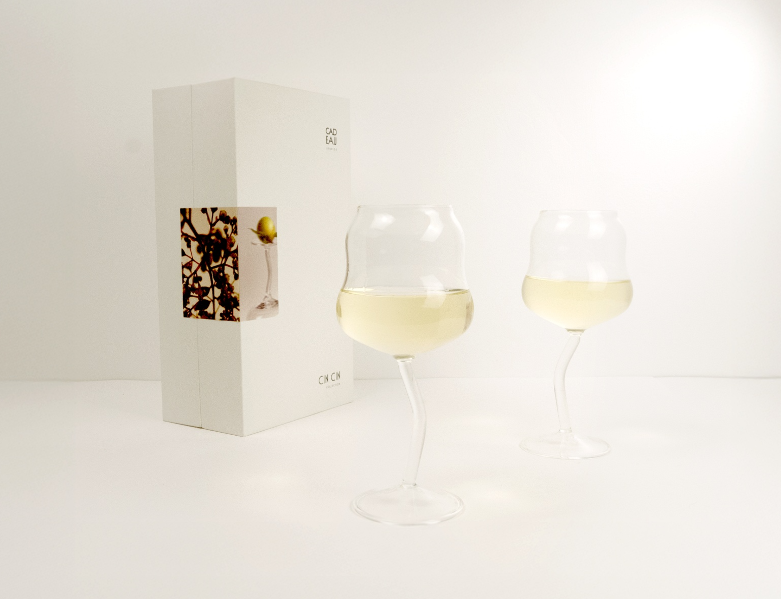Two wine glasses with white wine on a white background