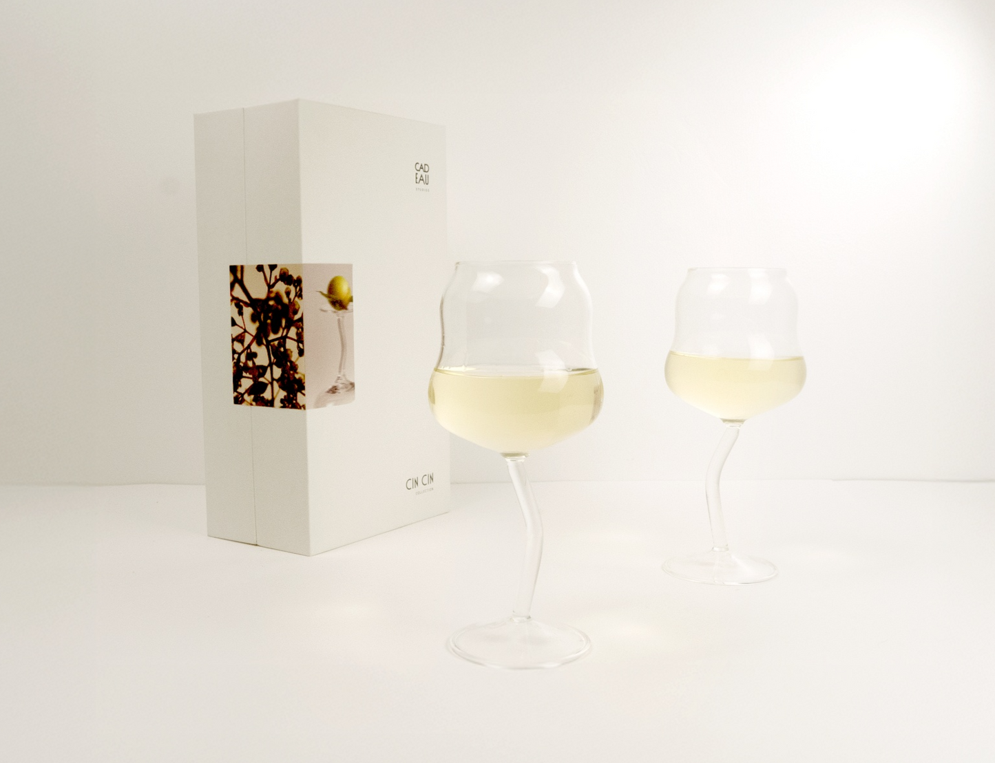 Two wine glasses with white wine on a white background