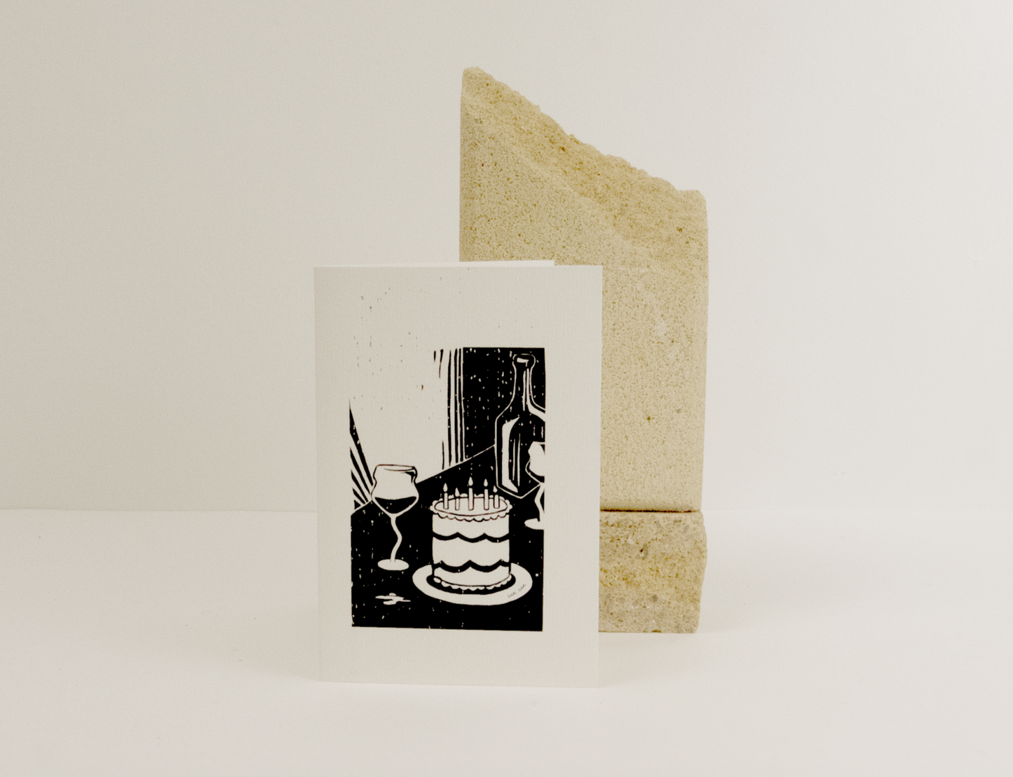 Greeting card with a minimalist design of a cake on a white background