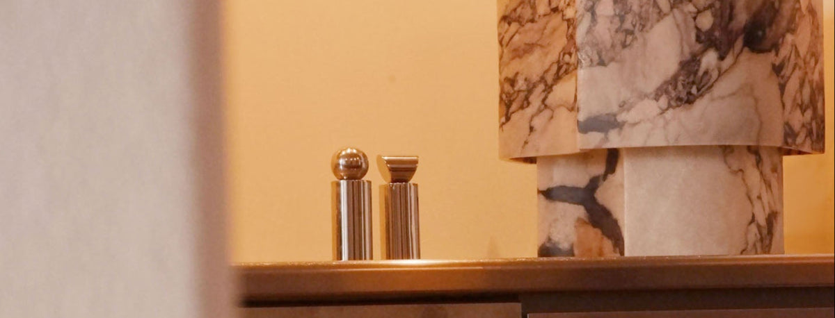 Salt and pepper grinders in modern aluminium kitchen with marble lamp