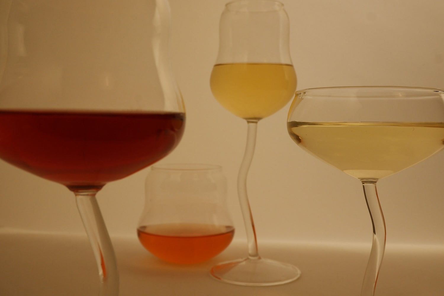 Five wine glasses with different types of wine on a white background