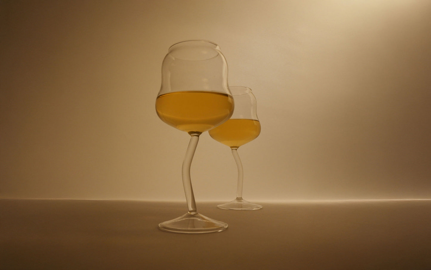 Two glasses of white wine on a beige background