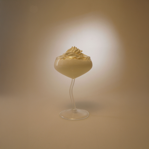 Glass filled with whipped cream on a beige background