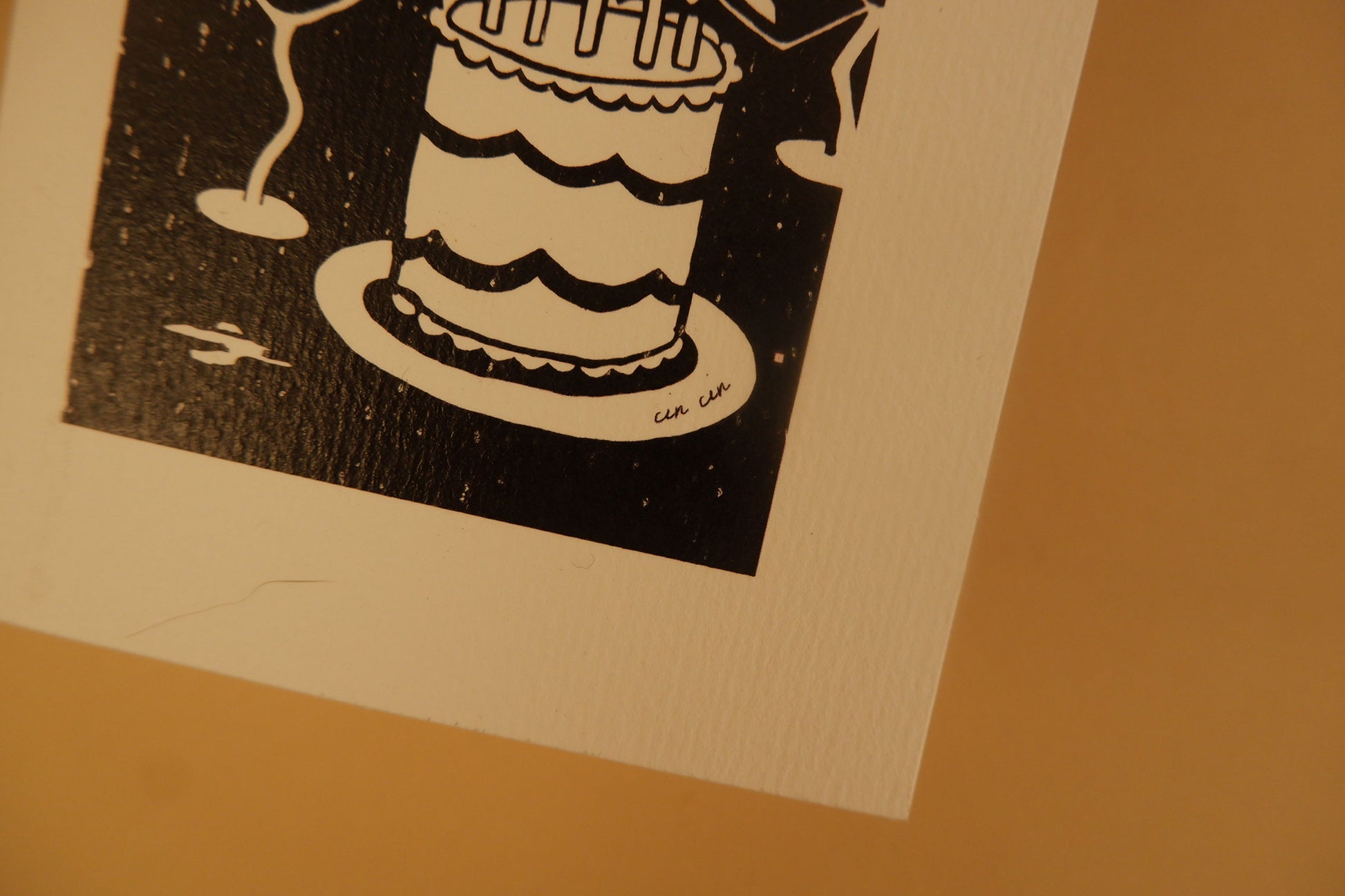 Black and white illustration of a cake on a beige background