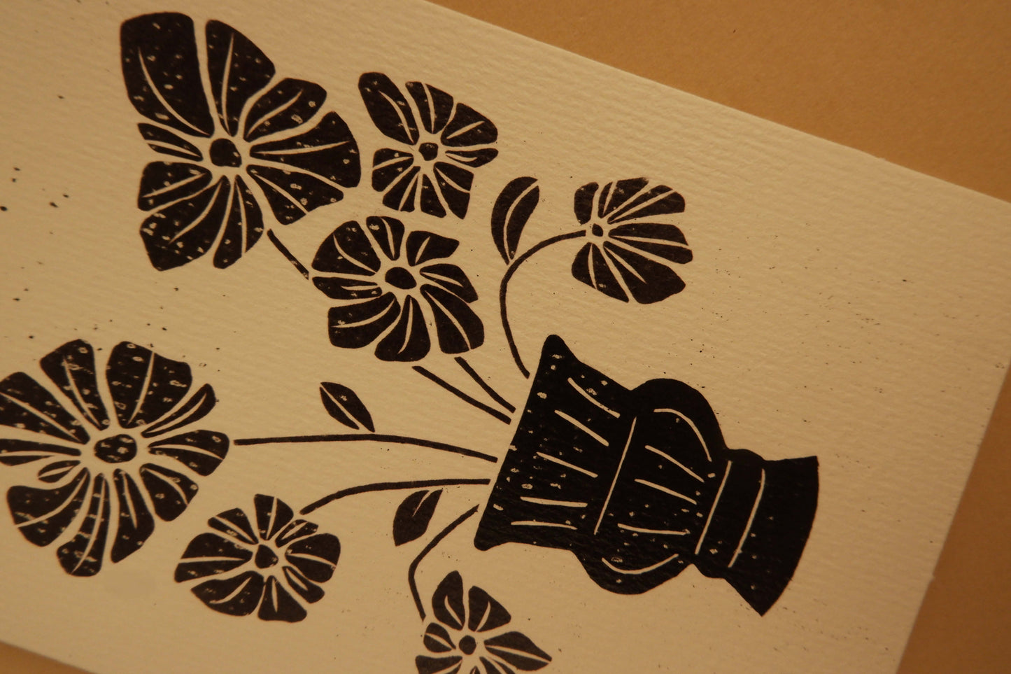 Black floral and vase design on beige paper