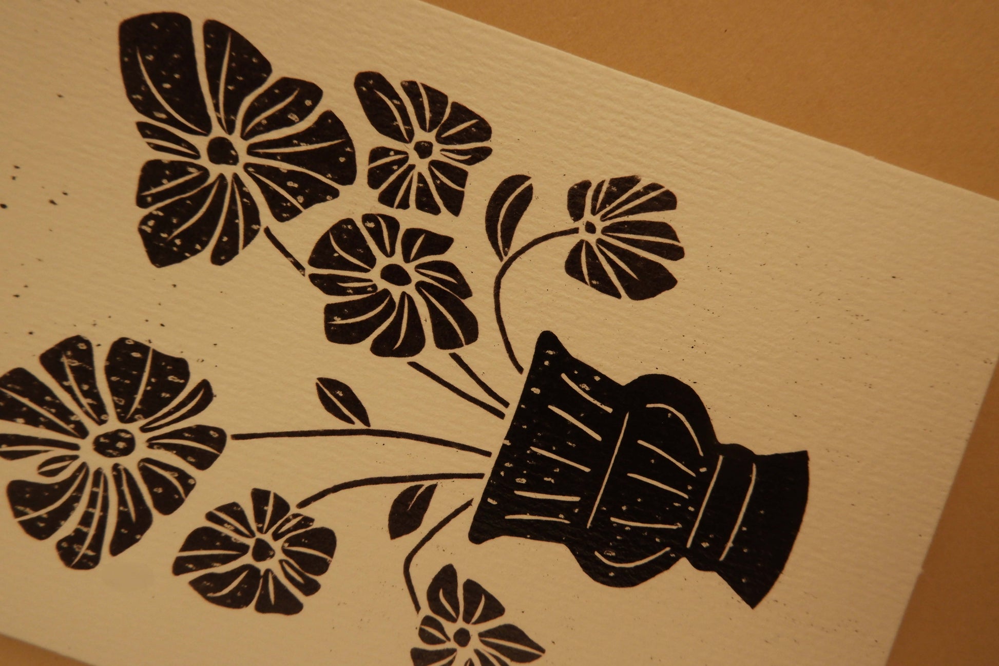 Black floral and vase design on beige paper