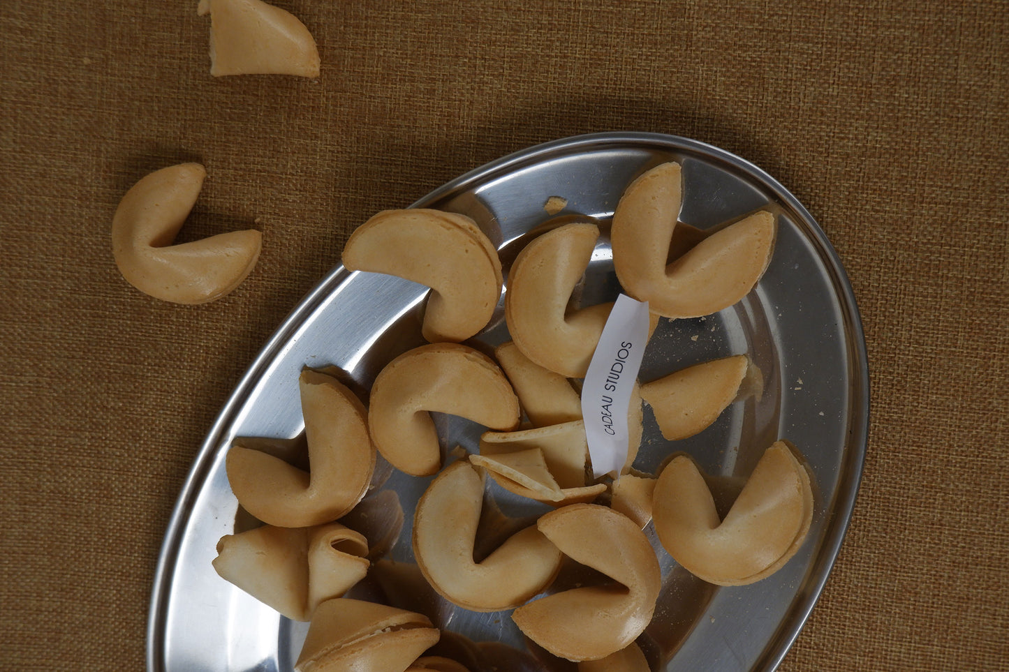 Fortune cookies on a metal tray with a brown textured background