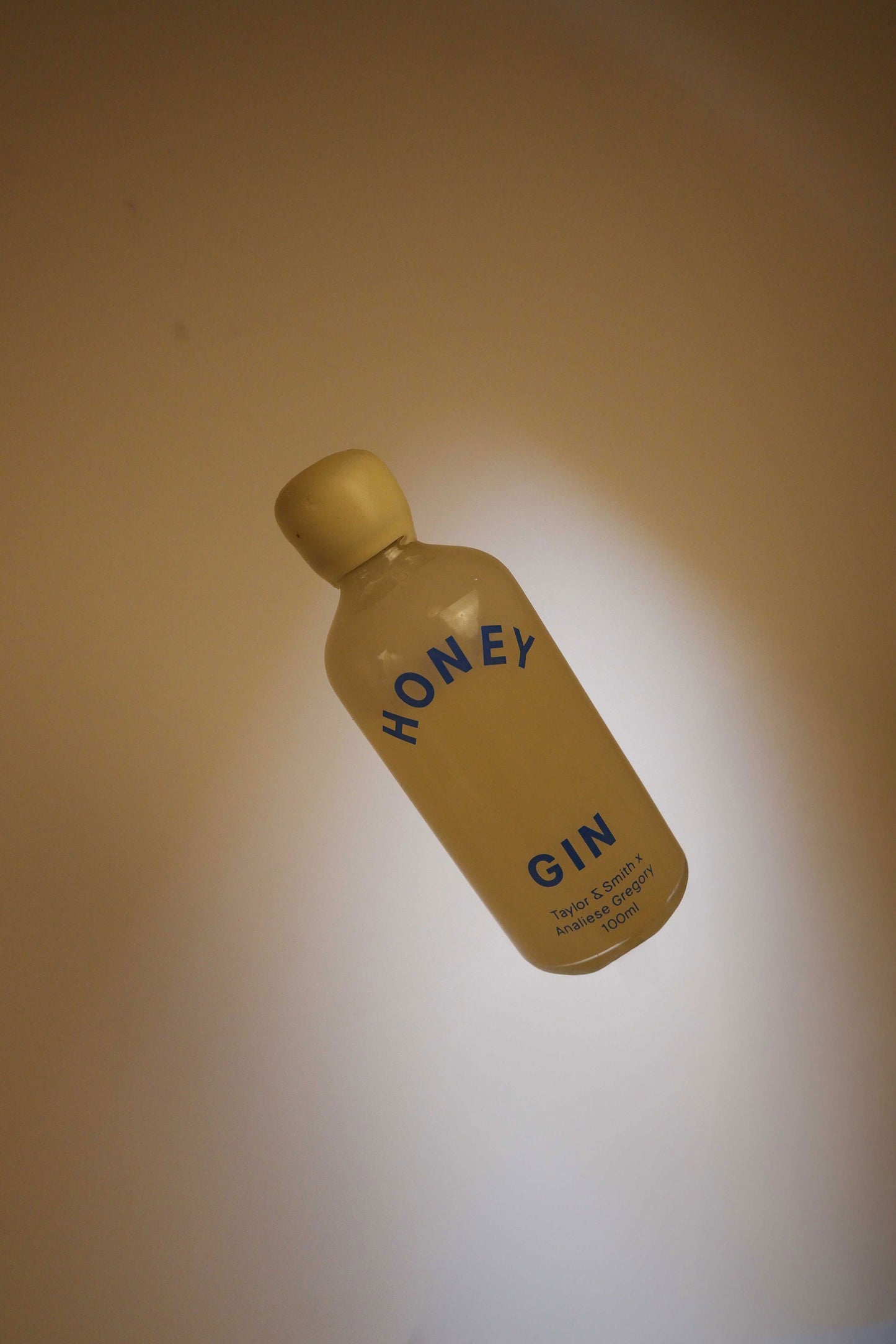 Bottle of honey gin on a beige background