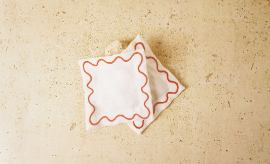 White cocktail napkins with red wavy embroidered border