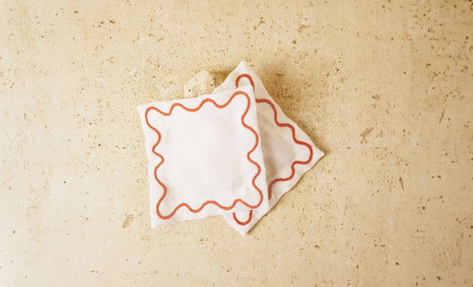 White cocktail napkins with red wavy embroidered border
