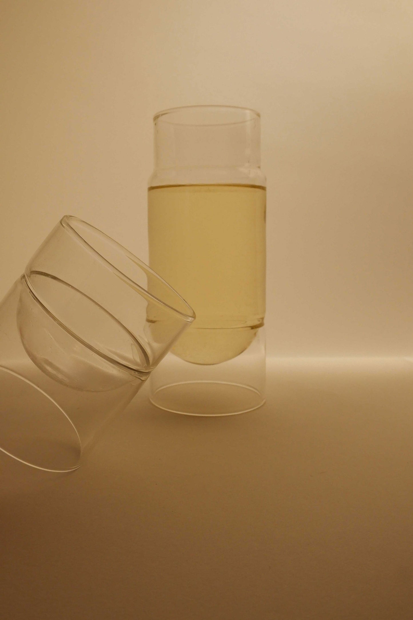 Two glasses of white wine on a beige background