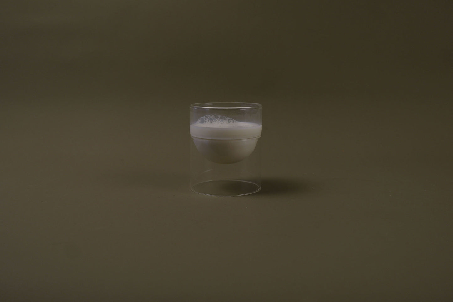 Clear glass with white foam on a dark brown background