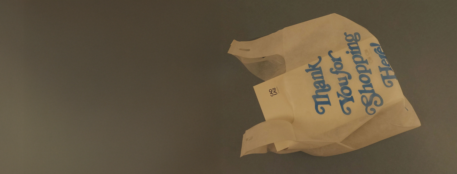 Worn plastic shopping bag with 'Thank You for Your Shopping Here' text on a dark background